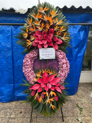 تاج گل تبریک نمایشگاه | با گل های آنتریوم هلندی، استرزیا و کرزنتیا روی پایه فلزی در ارتفاع ۲.۵ متری